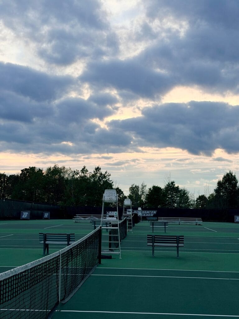 The Binghamton University tennis courts at dusk under a cloudy sky.